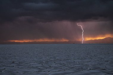 Gün batımında tuzlu ve düz çölde fırtına