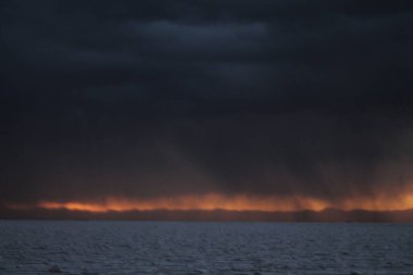 Gün batımında tuzlu ve düz çölde fırtına