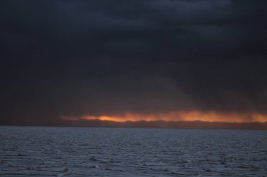 Gün batımında tuzlu ve düz çölde fırtına