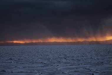 Gün batımında tuzlu ve düz çölde fırtına