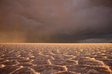 Gün batımında tuzlu ve düz çölde fırtına