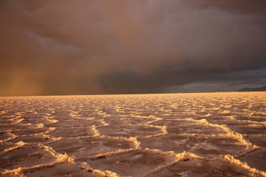 Gün batımında tuzlu ve düz çölde fırtına