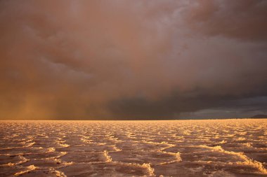 Gün batımında tuzlu ve düz çölde fırtına