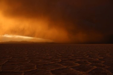 Gün batımında tuzlu ve düz çölde fırtına