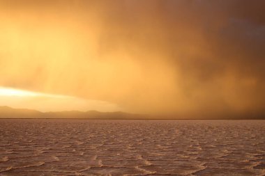 Gün batımında tuzlu ve düz çölde fırtına