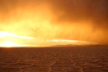 Gün batımında tuzlu ve düz çölde fırtına