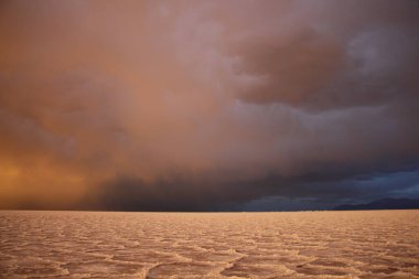 Gün batımında tuzlu ve düz çölde fırtına