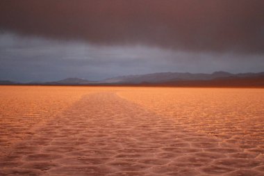Gün batımında tuzlu ve düz çölde fırtına