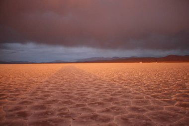 Gün batımında tuzlu ve düz çölde fırtına