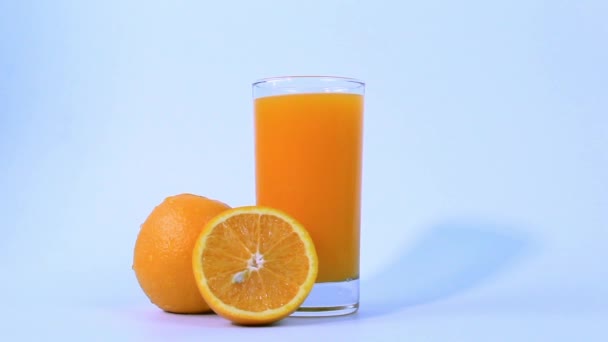 Ett Glas Färsk Apelsinjuice Med Apelsinfrukter Skivad Mitten Isolerad Vit — Stockvideo