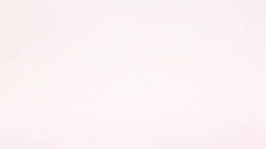 Hareket eden bir bardak buzlu kola, merkezdeki beyaz arka planda siyah kola ile doludur.