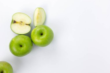 Beyaz zemin üzerinde yarım dilimlenmiş yeşil elmalar, pişirmek için sağlıklı organik elmalar, organik meyve konsepti tasarımı