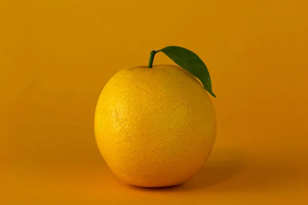 Juicy lemon isolated on yellow background. A lemon used for healthy fruit concept design, Orange fruit with orange slices and leaf isolated on yellow background