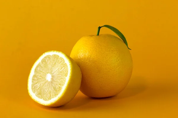 Organic lemon fruits and a Lemon slice with leaf isolated on yellow background