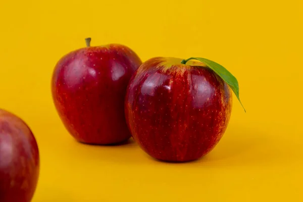 Two red apples isolated on yellow background. Two fresh apples fruits used for healthy food concept