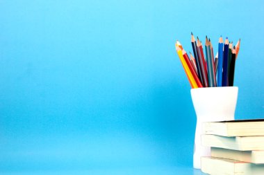 School accessories and education elements, books and alarm clock on Light blue background. Back to school concept concept posters