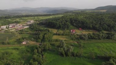 Sinema çekimleri post-processing olmadan (orijinal dosya, post prodüksiyon yok). Karpatlar 'da dağ ve ev manzaralı 4K hava uçuşu. Sıcak, güneşli yaz akşamı