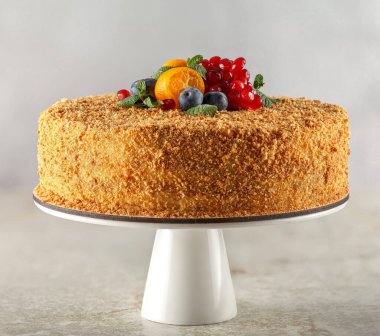 Şeker hastaları için karamel, portakal, nane, nar dilimleri ve yaban mersiniyle süslenmiş ballı kek.