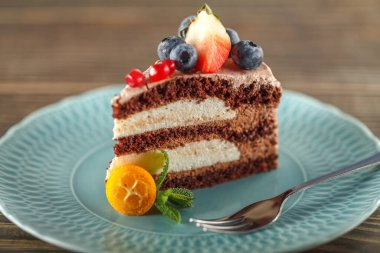 Yulaf ezmesi ve badem unlu çikolatalı kek, yabanmersini, nar tohumu, çilek ve taze nane yapraklarıyla süslenmiş. Çikolatalı krema şekersiz, sütsüz ve süzme peynirli.