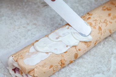 Pasta şefi yeni pişmiş kremaya krema sürüyor.