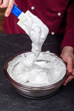 Fırında pişirmek için çırpılmış yumurta beyazını şekerle ve doğranmış fındıkla karıştırmak