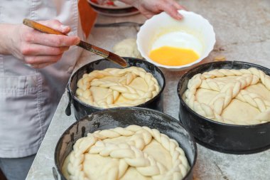 Şekerci, Paskalya pastasını pişirmek, yağlamak ve çırpılmış yumurta pişirmek için ürünü hazırlar.