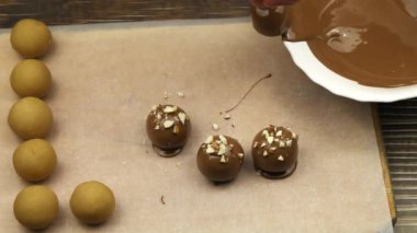 The process of making candies at home. Glazing black chocolate candies.
