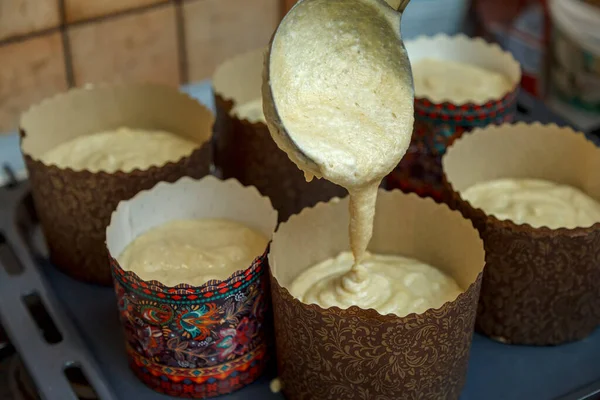 The mixture of rice, corn and almond flour with vegetable milk is poured into the forms for baking Easter cake.