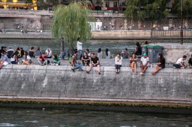 PARIS, FRANCE - 30 AĞUSTOS 2019: Kimliği belirsiz bir grup genç sıcak bir yaz akşamında Cite Adası 'nın setinde dinleniyor..