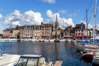 HONFLEUR, FRANCE - SEPTEMBER 1, 2019: Bu ortaçağ Saint Etienne kilisesi (14. yüzyıl) ve deniz kıyısındaki yat iskelesi manzarası.