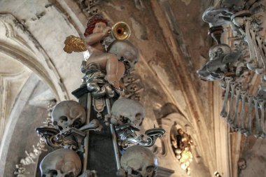 KUTNA HORA, CZECH - 28 Nisan 2012: Bu Kostnice Sedlec 'in mezarının içindeki insan kafatası piramidi üzerinde trompet çalan bir melek..