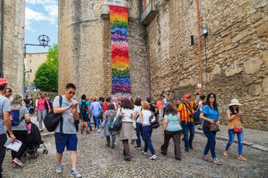 GİRONA, İSPAN - 14 Mayıs 2017: Bu, Çiçek Festivali vesilesiyle dekore edilen, eski şehrin duvarlarında kimliği belirsiz insanlarla dolu bir ortaçağ caddesi..