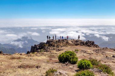 MADEIRA, PORTUGAL - AUGUST 22, 2021: Unidentified tourists on a high mountain viewing platform above the clouds covering the island and the ocean.