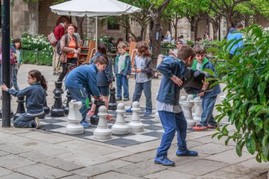 BARCELONA, İspanya - 10 Mayıs 2017: Kimliği belirsiz çocuklar Katalan Edebiyat Kütüphanesi 'nin avlusunda dev satrançla oynuyorlar.