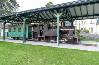 BAD ISCHL, AUSTRIA - 18 Mayıs 2019: Bu yeniden inşa edilmiş eski bir buhar lokomotifi ve tren istasyonuna yerleştirilmiş bir vagon.