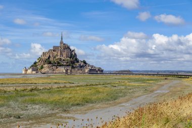 MONT SAINT-MICHEL, FRANCE - 2 Eylül 2019: Bu, Couesnon nehrinin ağzında deniz tarafından taşan ortaçağ manastırı ile güçlendirilmiş küçük bir kayalık ada.