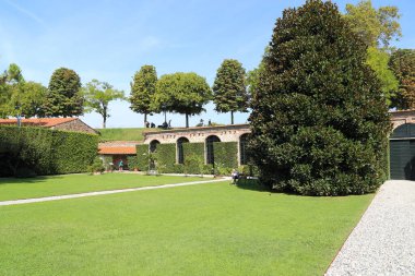 LUCCA, ITALY - 16 Eylül 2018: Bu Palazzo Pfanner bahçesinin girişindeki ek binaların yakınında çakıl yolu olan bir çimenlik..