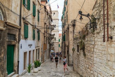 SIBENIK, CROATIA - 9 Eylül 2016: Bu eski bir ortaçağ sokağı ve bir sonbahar akşamında St. John Kilisesi saati olan çan kulesi.