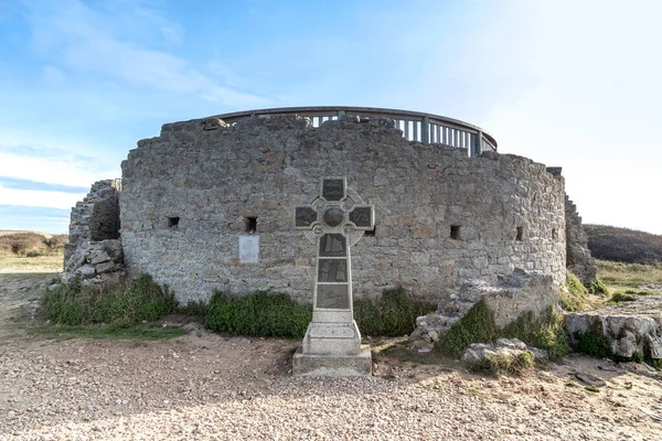 FRANCE - SEPTEMBER 6, 2019: This is an ancient Celtic cross near the remains of an old medieval tower on Pointe du Raz.