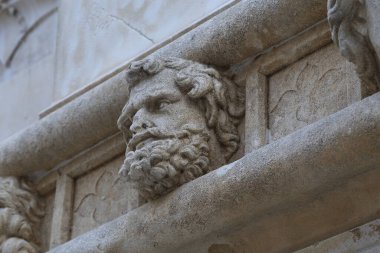 SIBENIK, CROATIA - SEPTEMBER 9, 2016: This is a fragment of a frieze with one of the 71 sculptures of faces on the outside of the apse of the Cathedral of St. James.