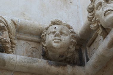 SIBENIK, CROATIA - SEPTEMBER 9, 2016: This is a fragment of a frieze with one of the 71 sculptures of faces on the outside of the apse of the Cathedral of St. James.