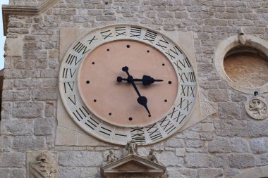 SIBENIK, CROATIA - SEPTEMBER 9, 2016: This is an old tower clock with a 24-hour dial on the facade of the church of St. Barbara.