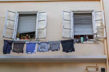 SIBENIK, CROATIA - SEPTEMBER 9, 2016: This is household trifle of the old city - drying clothes in the windows of the house above the street.