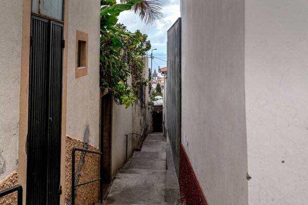 FUNCHAL, MAFEIRA - AUGUST 25, 2021: This is one of the narrow passage-stairs in the old upland area of the city.