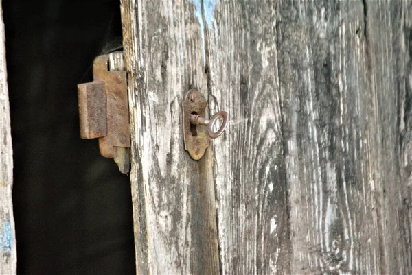 Paslı anahtarı olan eski kulübe kapısı.
