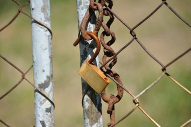 Kafesteki paslı metal zincir.