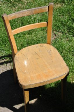 Parktaki ahşap bankta boş bir sandalye.