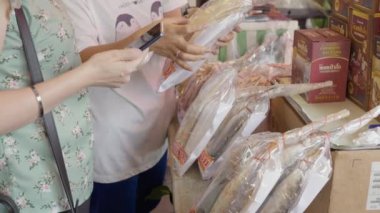 Sri Racha, Chonburi, Tayland - 16 Haziran 2022 - Tayland 'ın Chonburi kentindeki Nong Mon pazarındaki yerel bir dükkandan yiyecek almak için turist dükkanı