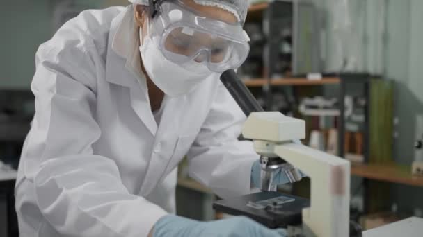Laboratuvarında Mikroskopla Çalışırken Notlar Alırken Güvenlik Maskesi Saç Filesi Takan — Stok video