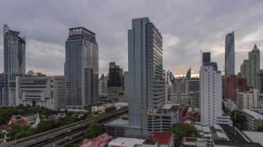 Bangkok, Thailand - 10 August 2022 - Time lapse view of Bangkok cityscape with high-rise buildings and BTS skytrains